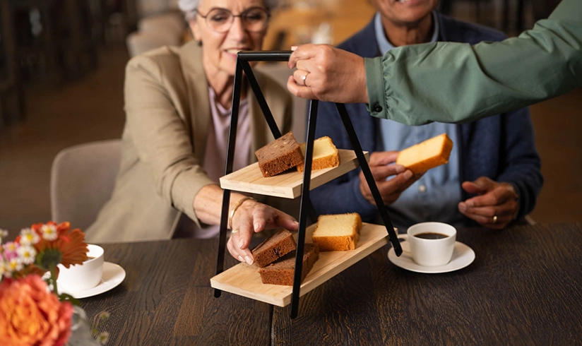 Vrouw pakt plakje cake van etagiere