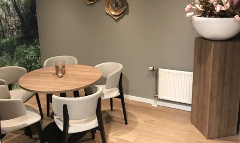 Kamer met een ronde tafel en witte stoelen eromheen