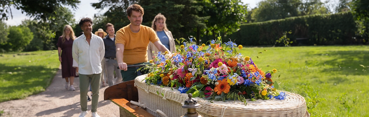 Uitvaart bakfiets met uitvaartkist met kleurrijke bloemen