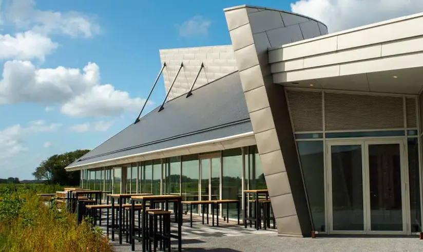 Terras aan de buitenkant van een groot gebouw met grote raampartijen