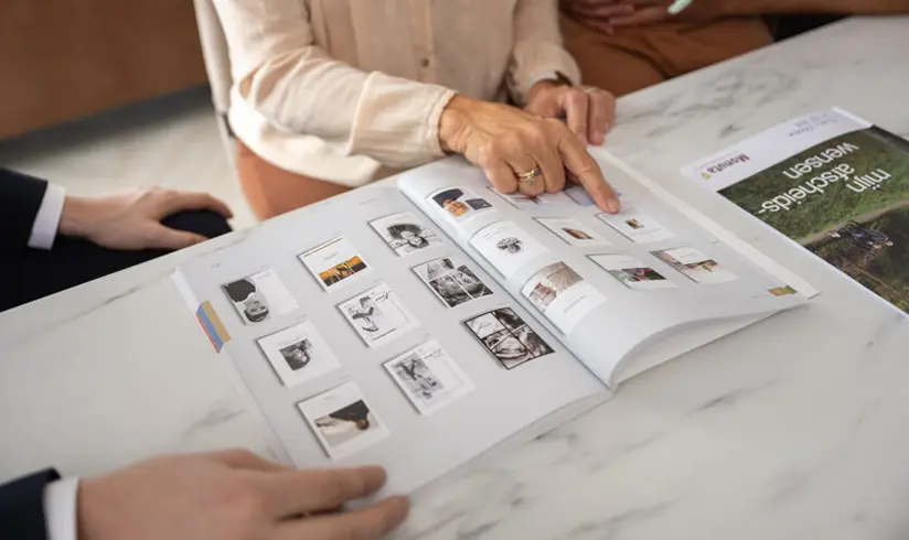 Op een tafel ligt een boek met voorbeelden van rouwkaarten