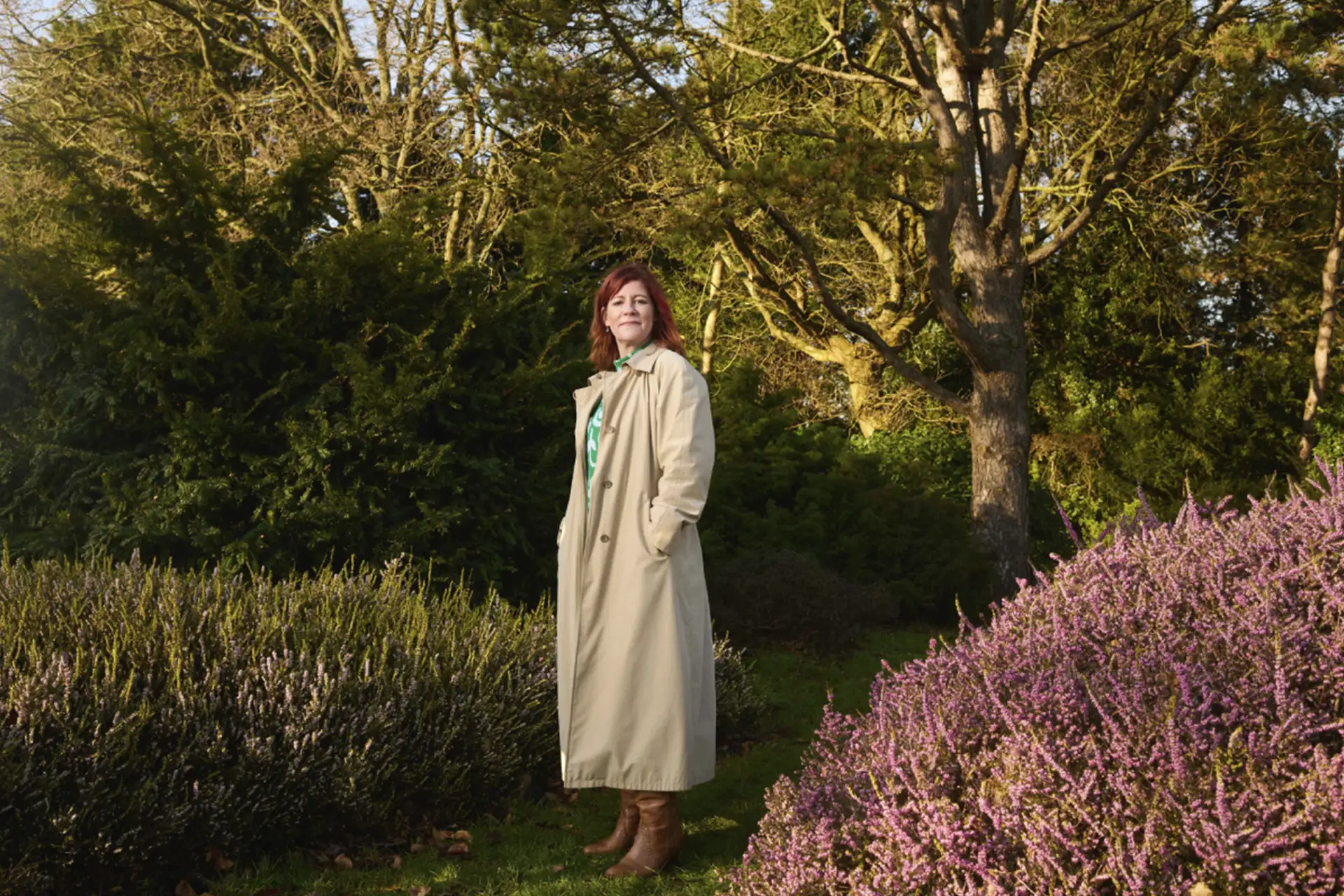 Vrouw met rode haren in de natuur met heide