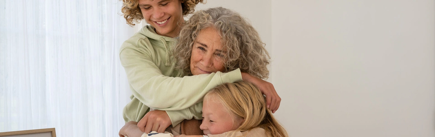 Oma knuffelt met kleinzoon en kleindochter