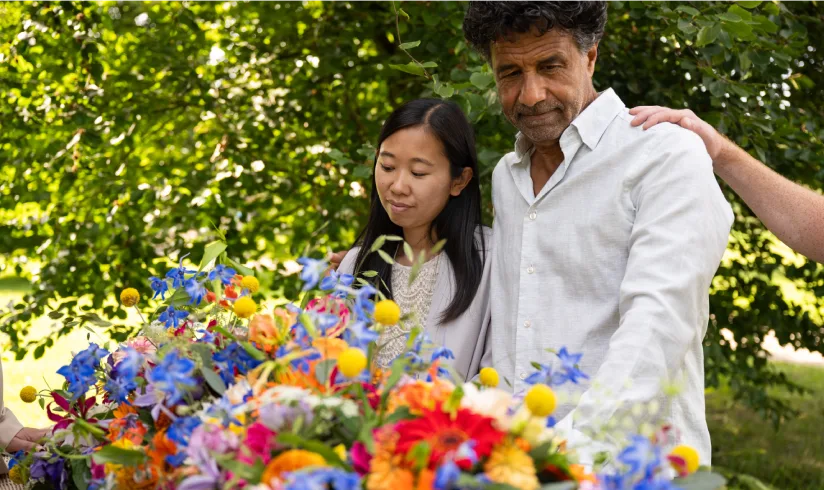 genodigden rondom rotan kist bekleed met bloemen