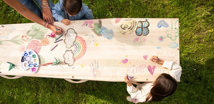 Kinderen tekenen op kist in de natuur
