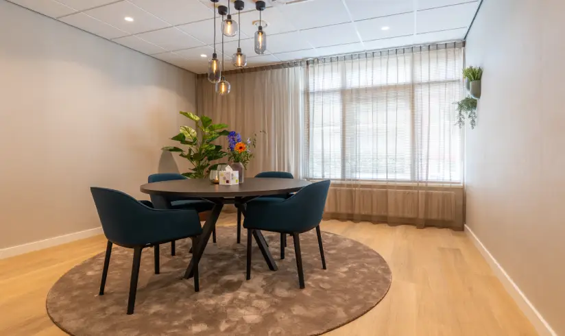 Kamer met tafel en stoelen met bloemen en kaarsjes