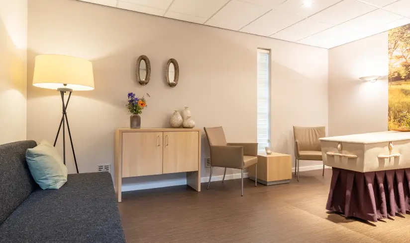 Een ruimte met een bank, stoelen, en een kist