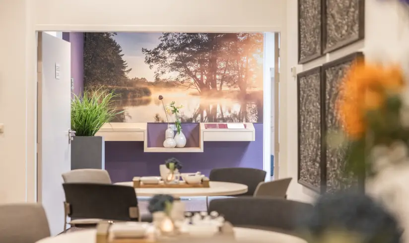 Een ruimte met tafels en stoelen, met opstaande deuren naar de hal