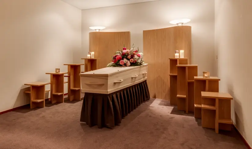 Opbaarkamer met kist en de zithoek met stoelen en banken