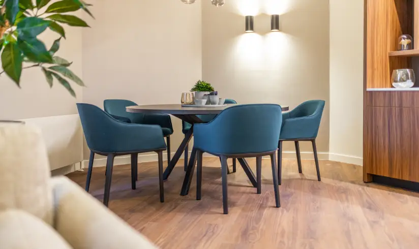 Een kamer met een zwarte tafel en 4 stoelen eromheen