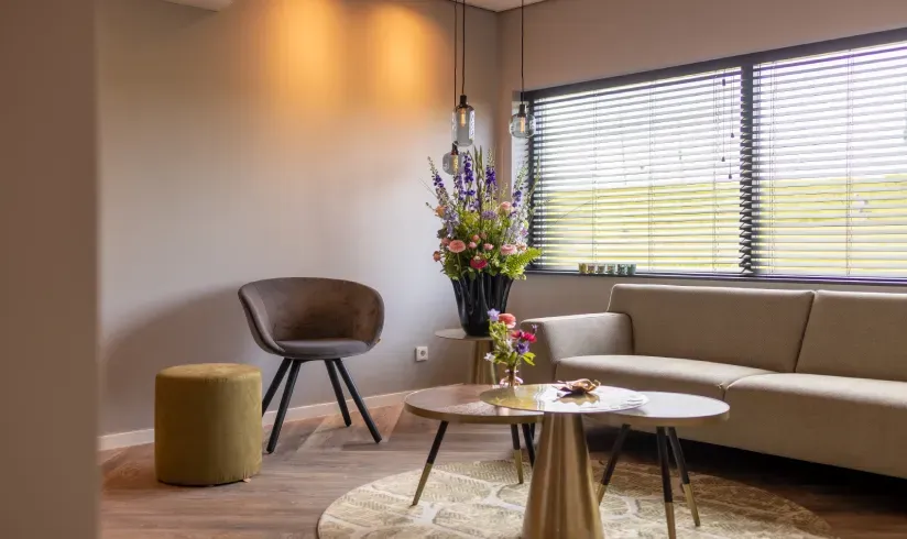 Een hoek met een bank, een stoel en 2 kleine salontafeltjes