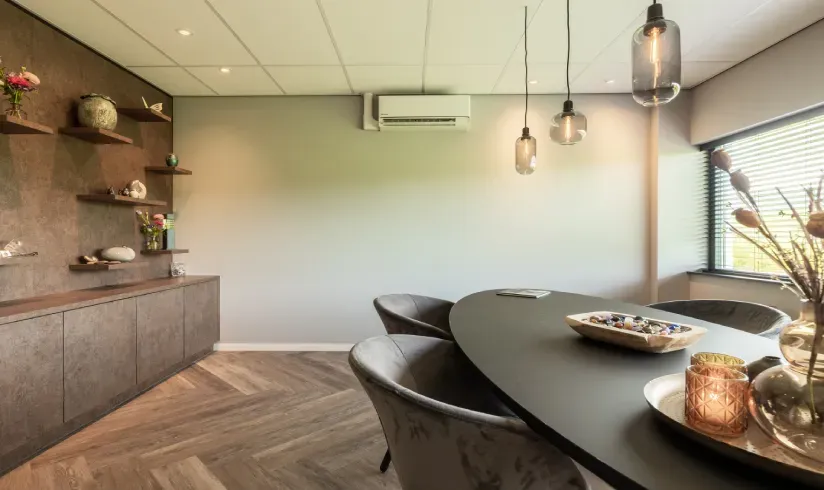 Kamer met een kast en een zwarte tafel met twee grijze stoelen