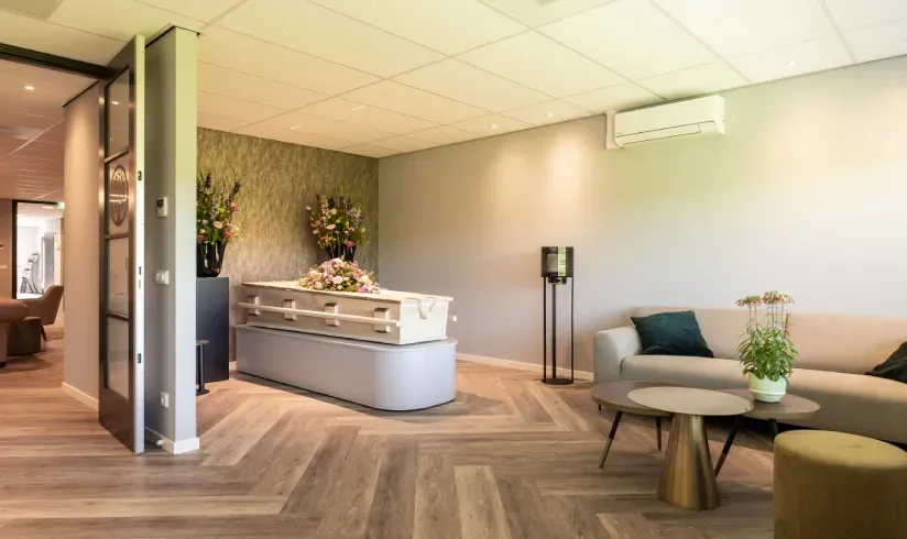 Kamer met een houten uitvaartkist en een bank