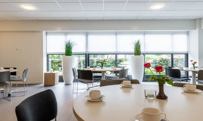 grote ruimte met een close up op een witte tafel met lege koffiekopjes