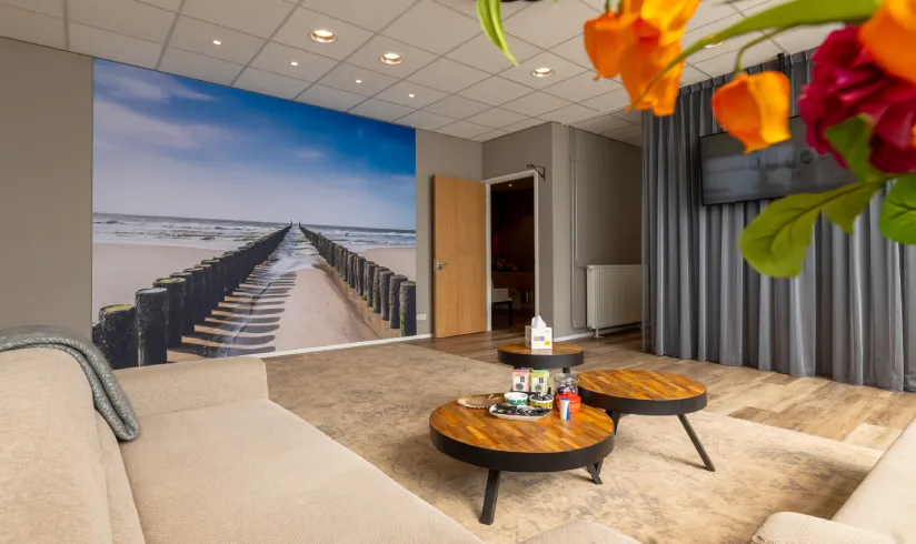 Een kamer met een tafel en een hoek met een koffiemachine