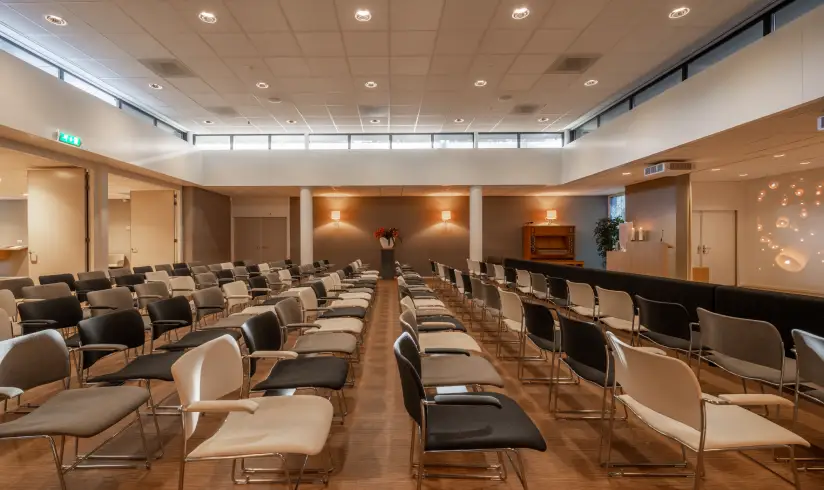 Grote zaal met rijen stoelen, gezien vanaf de zijkant