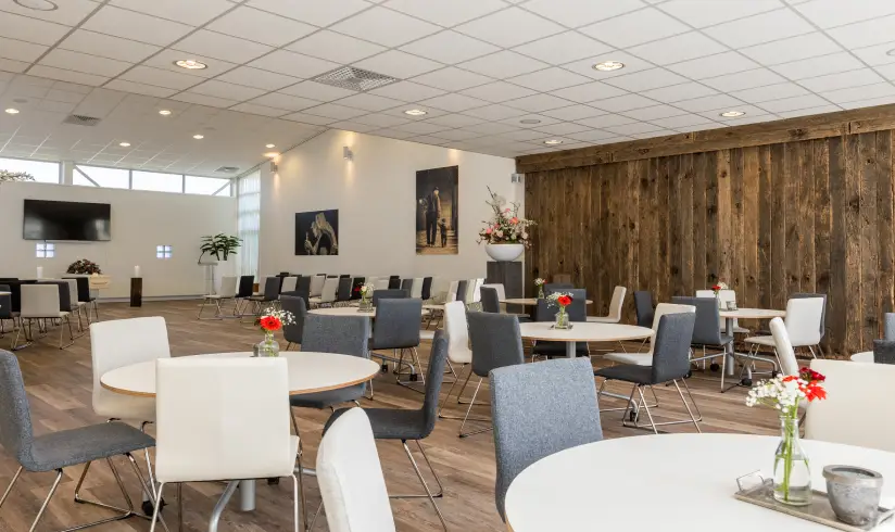 Grote ruimte met witte tafels en zwarte en witte stoelen
