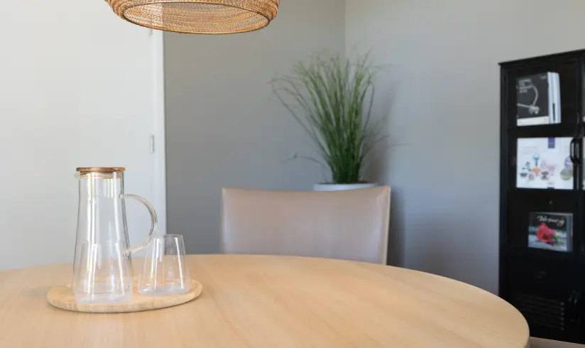 Een tafel met daarop een dienblad met een kan water en een aantal glazen