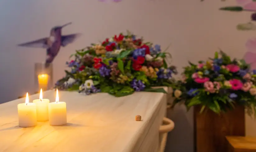 Close up van een kist met bloemen en brandende kaarsen