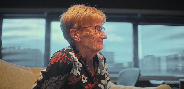 Vrouw genaamd Betty kijkt glimlachend weg bij November 2 Remember campagne