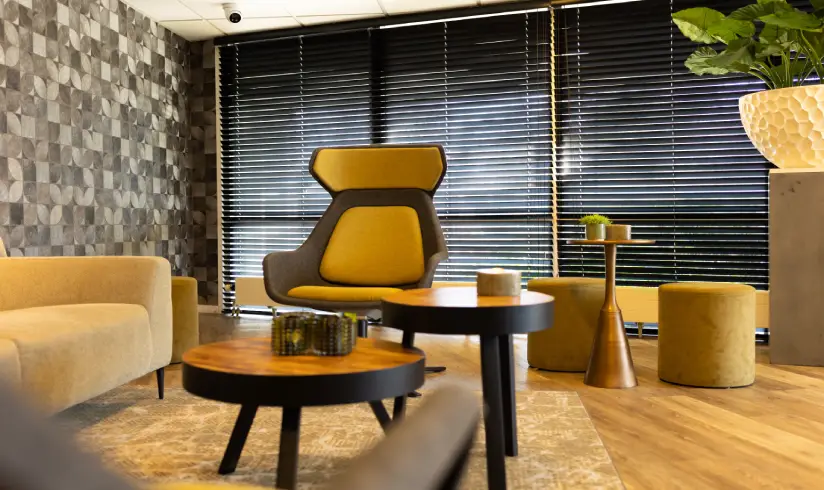 Kamer met een zithoek met een bank en fauteuil, en een salontafel in het midden