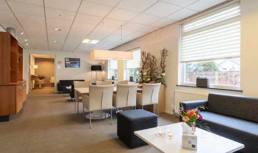 Woonkamer met een zithoek met bank en een tafel met stoelen