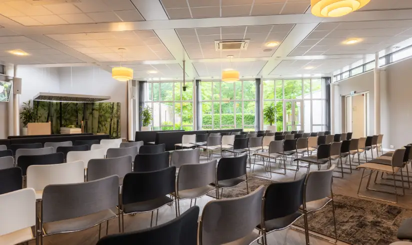 Grote ruimte met rijen stoelen voor een afscheidsdienst
