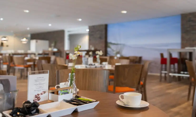 Grote ruimte met tafels en stoelen, close up op een tafel met koffiekopje
