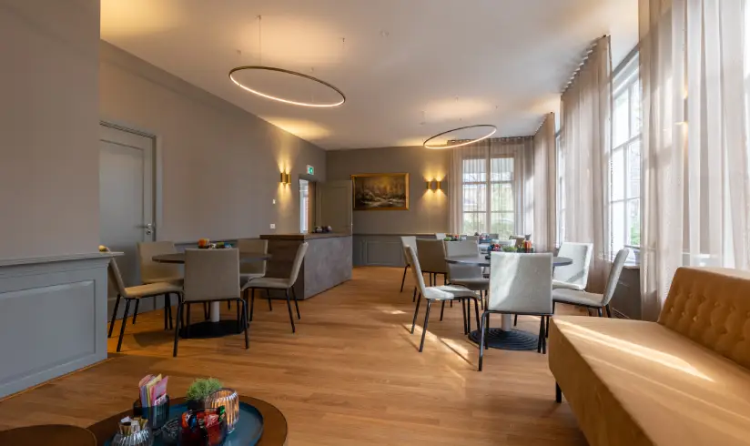 Grote ruimte met tafels en stoelen en een bar aan de muur