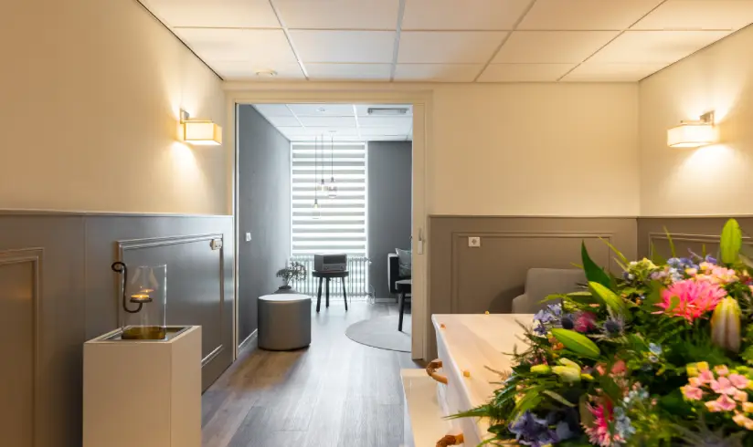 Kamer met een kist met bloemen en een doorkijk naar de familiekamer