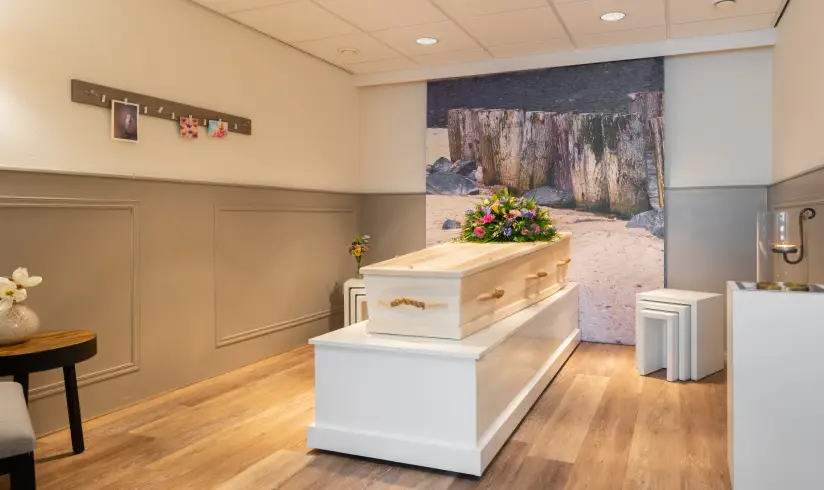 Kamer met een uitvaartkist met bloemen