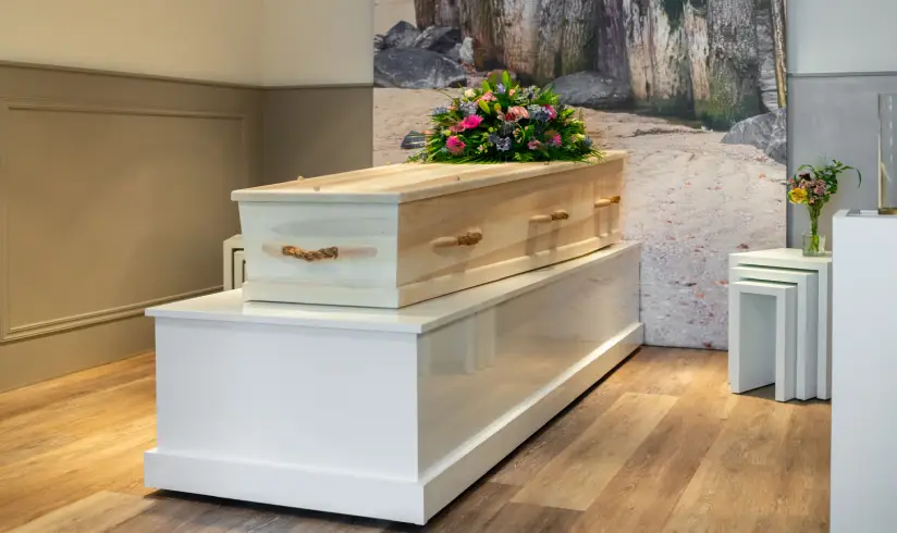 Kamer met uitvaartkist met bloemen