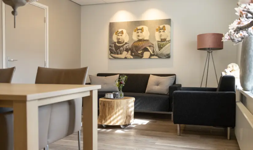 Kamer met een tafel met stoelen en een zithoek met 2 banken