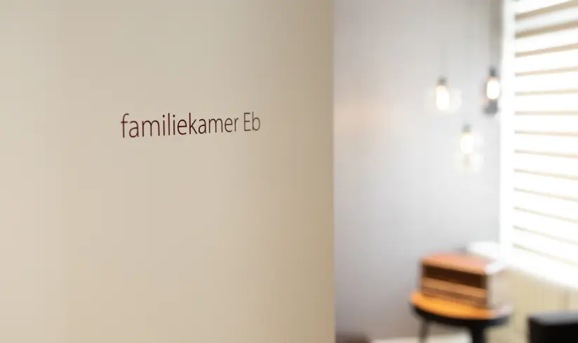 Close up van een deur met daarop 'Familiekamer Eb'