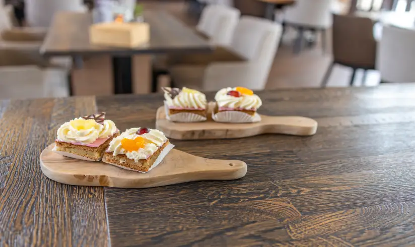 2 plankjes met 2 gebakjes erop op een houten tafel