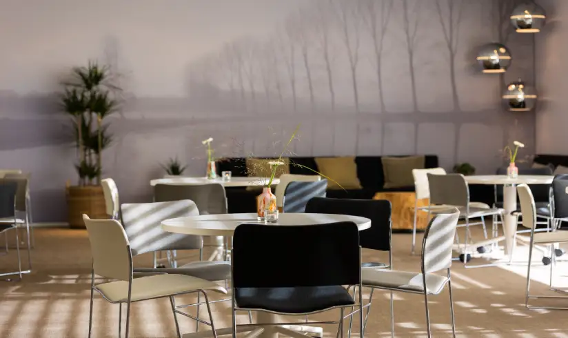 Ruimte met tafels en stoelen een bank tegen de muur
