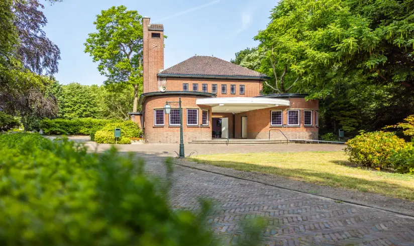 Een stenen gebouw omringd door groene bomen