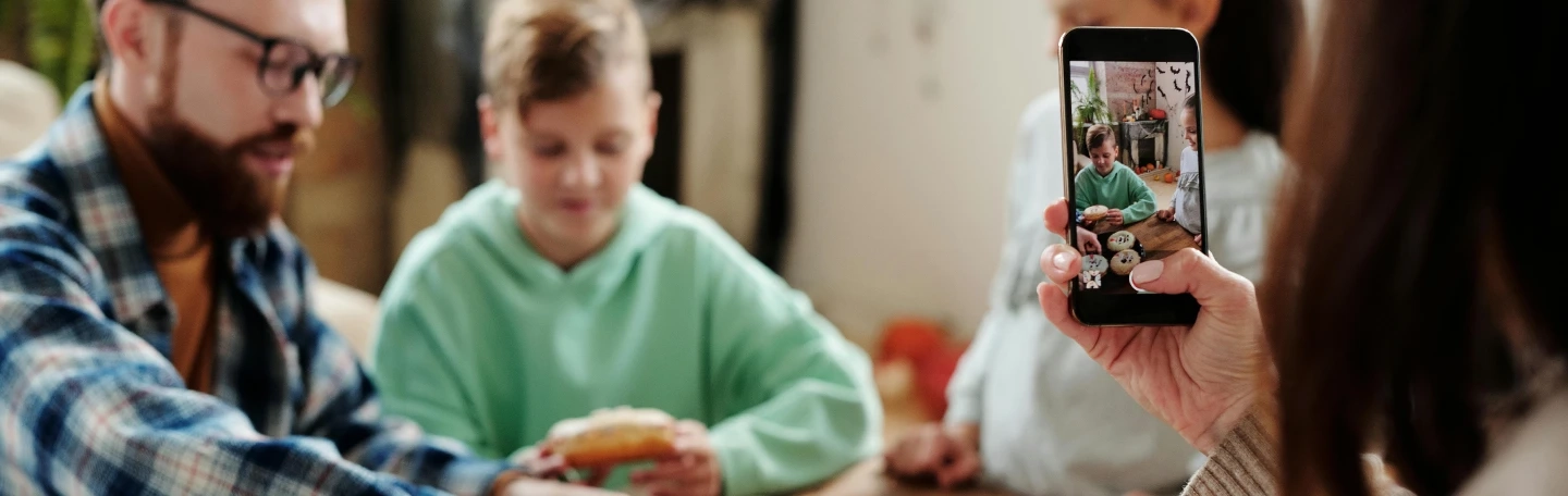 moeder fotografeert zoon met donut