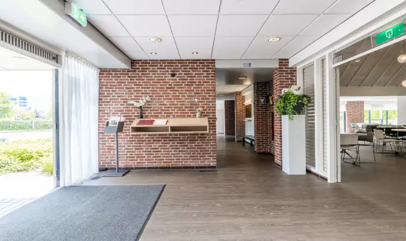 Een hal met grote openslaande deuren naar buiten