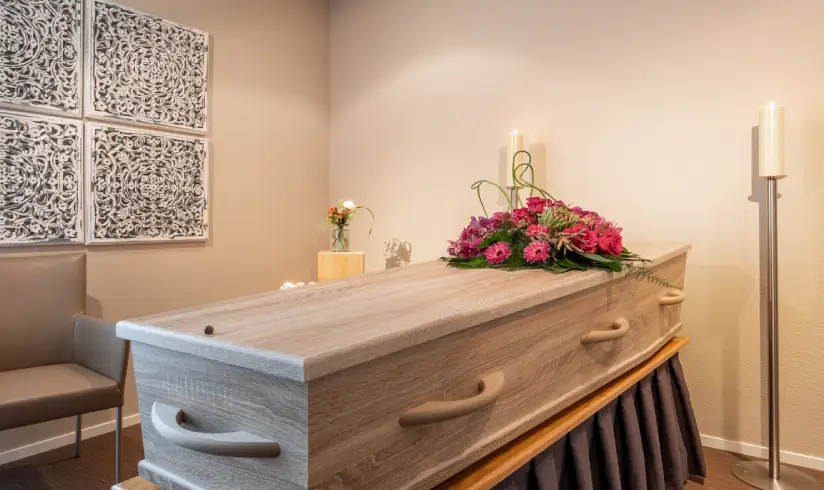 Kamer met een uitvaartkist met bloemen