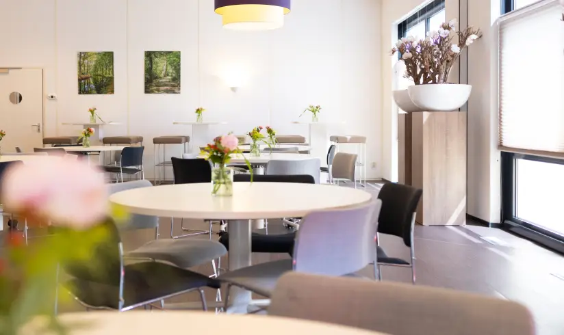Ruimte met tafels en stoelen naast het raam