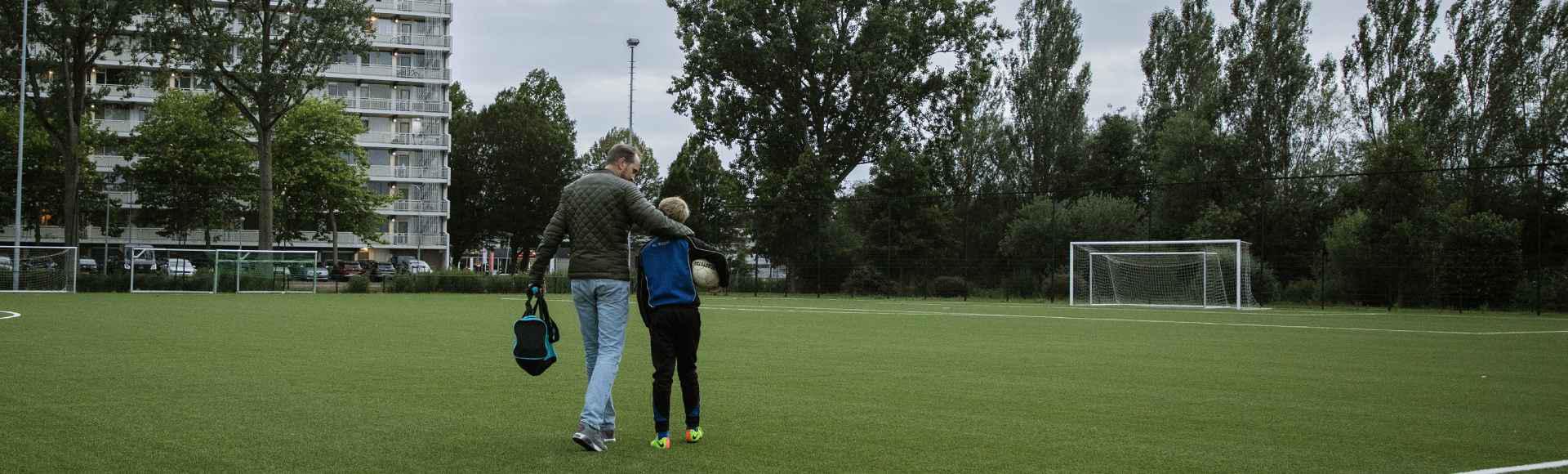 Header-vader-zoon-voetbalveld-na-training