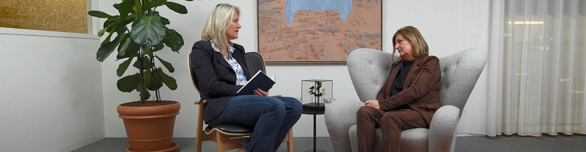 Suzan en Pauline zitten tegenover elkaar in stoelen en kijken elkaar aan