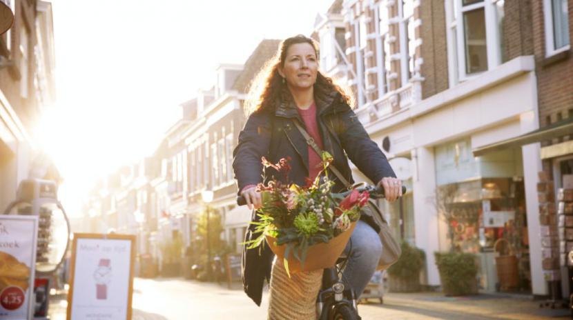 Vrouw op de fiets door de stad