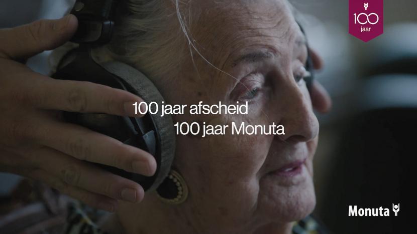 Greetje van 100 zit met een koptelefoon op achter de microfoon